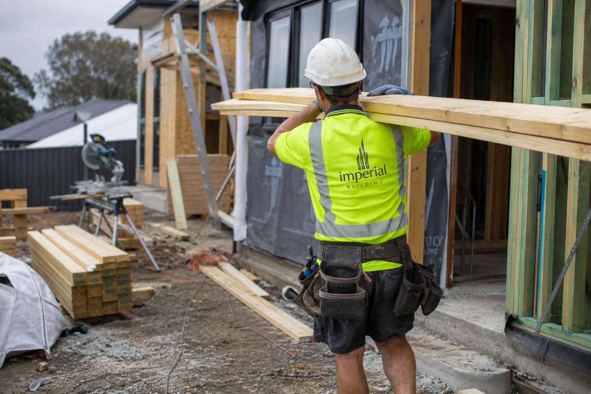 Builder carrying materials on a residential construction site