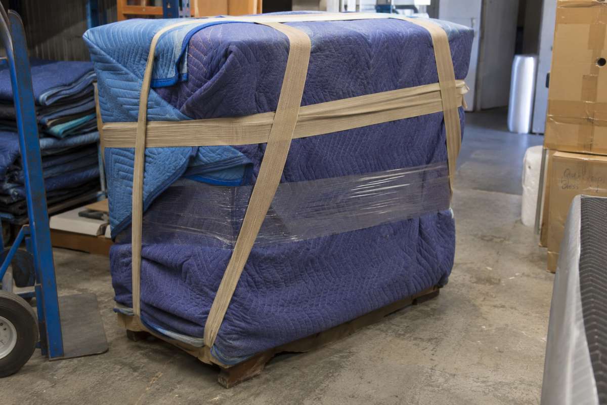 Antique chest of drawers wrapped in blankets for safe transport